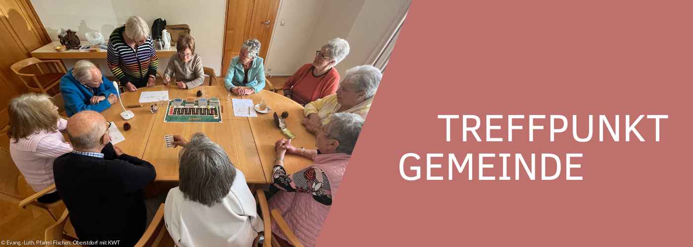 Verschiedene Personen, die miteinander am Tisch sitzen und ein Brettspiel spielen