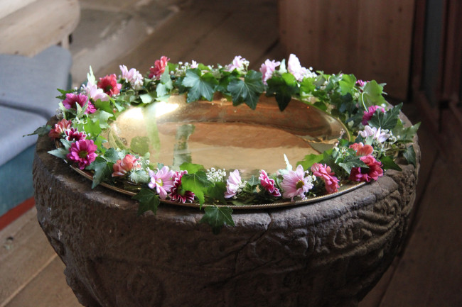 Blumenschmuck auf Taufstein